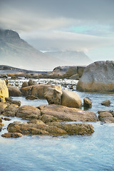 Image showing Ocean, rocks and landscape with beach and outdoor, travel with summer vacation in South Africa. Environment, seaside location and tropical destination with journey to sea and nature with adventure