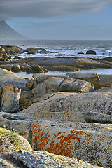 Image showing Ocean, rocks and landscape with beach and waves, travel with summer vacation and outdoor. Environment, sea view and seaside location with tropical destination and journey with nature and adventure