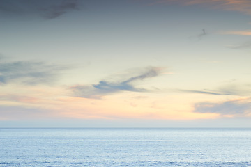 Image showing Beach, sunset and sky by the ocean for travel with a seascape or tropical vacation in Australia. Nature, island and sea water waves in the evening for an outdoor paradise holiday or weekend trip.