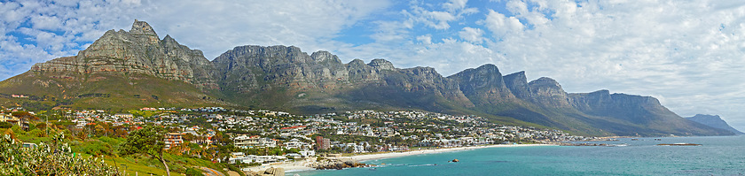 Image showing Mountain, travel and city by ocean in South Africa for tourism, traveling and global destination. Landscape, background and scenic view of beach by urban town for coastline, vacation and holiday