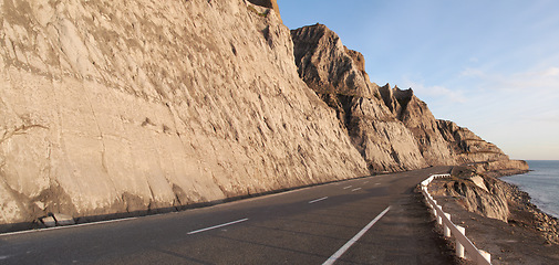 Image showing Road, mountain and travel with coastal landscape, direction and destination with asphalt and nature. Environment, street and beach location with journey and traveling view outdoor with horizon