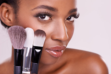 Image showing Skincare, makeup brushes and portrait of black woman with brush on face in studio with cosmetic application tool. Skin care, blush and cosmetics, beauty model with luxury powder on pink background.