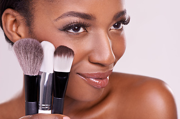 Image showing Cosmetic brushes, makeup and black woman with smile on face in studio and beauty application tool. Skincare, blush and cosmetics, facial skin model with luxury contour product on white background