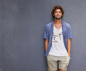 Image showing Confidence, casual and male model by a wall with mockup space with a hipster, cool and stylish outfit. Happy, positive and handsome man with trendy style or fashion by a gray background with mock up.