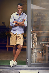 Image showing Laughing, coffee shop and man as small business owner at front door with arms crossed. Black entrepreneur person as barista, manager or funny waiter in restaurant for service, thinking and goals