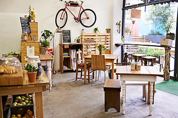 Image showing Empty, coffee shop and interior space with table, chairs and furniture or small business, bistro and cafe with unique design and style. Background, creative startup and food store with bike on wall