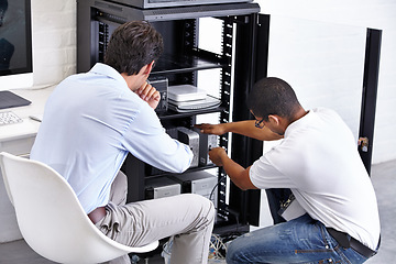 Image showing Server room, man and technician working with electronics for hardware maintenance of glitch in office. IT support, worker and electrical engineer fixing internet connection for information technology