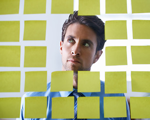Image showing Businessman, face and thinking with sticky note for brainstorming, planning agenda and ideas on glass at office. Focus man contemplating business decision, strategy and problem solving for solution