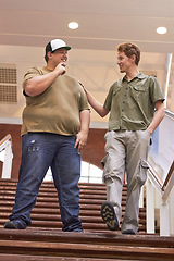 Image showing Student, teenager friends and boys walking down university and school steps with a smile. Conversation, talking and discussion of guy group feeing happy on education building stairs with a talk