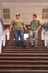 Image showing Student, teenager friends and campus boys walking down university and school steps with a smile. Conversation, talking and discussion of guy group feeling happy on education building stairs with talk