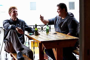 Image showing Men, friends laugh and drinking beer at a pub and restaurant with conversation and discussion. Alcohol, guys and young people together at diner with alcohol and drink with bottle and joke at table