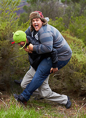 Image showing Piggy back, fun and man friends outdoor camping in nature playing and having fun together. Happy, smile and silly portrait of youth and men laughing in the forest on summer camp holiday by trees