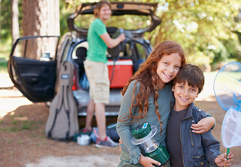 Image showing Happy siblings, portrait and hug for road trip, camping or family vacation together in nature. Sister hugging brother with smile and lantern for camp adventure, travel or holiday getaway in a forest