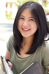 Image showing Portrait, education and book with an asian woman student on university campus for learning or development. Study, smile or happy with a young female college pupil outdoor to study or learn in summer