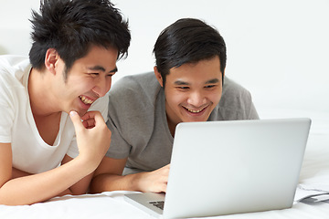 Image showing LGBT, laptop and an asian couple in bed together, watching a movie or reading an email in the morning. Love, smile or happy with a gay man and partner streaming an online subscription in the bedroom