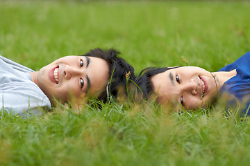 Image showing Happy, relax and portrait of a gay couple in the grass for love, bonding and happiness in a park. Smile, lgbtq and Asian men in nature for a date, romance and relaxing together on a lawn or field