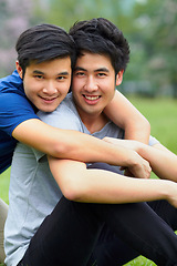 Image showing Asian men, gay couple and hug in park portrait, grass or garden with love, care and bonding in summer sunshine. Happy Japanese guy, romance or relax together on lawn with lgbtq, nature and holiday