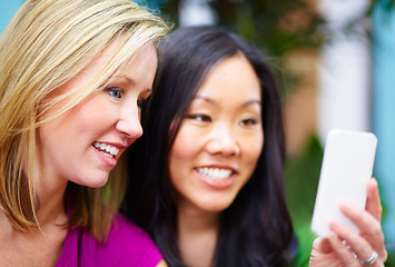 Image showing Phone, gossip and friends on social media, internet and share meme in an outdoor park together chatting on an app. Technology, happy and young people or women search the web, website on a smartphone