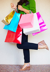 Image showing Shopping, legs and bags with a woman customer in studio on a white background for retail consumerism. Fashion, sale and shoes with a female consumer at a mall, store or luxury market as a shopper