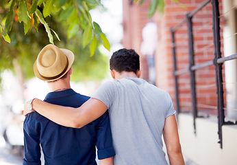 Image showing City, travel and back of gay couple walking together in the street while on a tourism vacation. Love, affection and male friends embracing in an outdoor urban road while on a weekend trip or holiday.