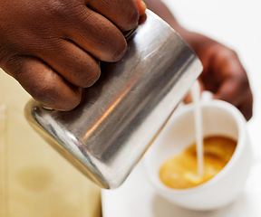 Image showing Hands, coffee and a barista pouring milk into a cup while working in a cafe for hospitality or service. Kitchen, beverage and caffeine with a waitress in a restaurant to prepare a drink closeup