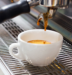 Image showing Coffee machine, restaurant and espresso or hot drink in a cup at a small business on counter top. Kitchen, cafe and pouring latte or caffeine at shop with preparation with electrical appliance.