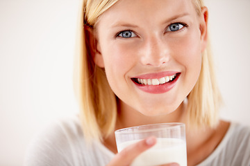 Image showing Dairy, woman drinking a glass of milk and in a white background with a smile. Health wellness or natural nutrition, healthy and female person drink with happy face in a studio background smiling