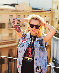 Image showing Tattoo, portrait and woman with sunglasses in city, urban body art or stylish fashion outdoor. Face, rooftop or trendy female person from Canada in cool denim clothes, jacket or serious punk attitude