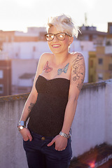 Image showing Portrait, stylish and woman on rooftop with tattoos, unique style and creativity in the city. Trendy, creative and a punk lady with fashionable, cool and urban clothes for fashion and summer