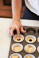 Image showing Hands, closeup and tray with berry on cupcake in bakery, cafe or kitchen with professional chef. Baker, muffin and start with dough, blackberry or job at small business, restaurant or coffee shop