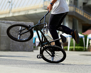 Image showing Fitness, cycling tricks and a man with a bicycle for sports, balance and action in the city. Training, energy and a person with a bike for speed, transportation and urban spinning on the concrete