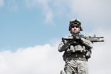 Image showing Soldier man, machine gun and outdoor portrait by sky background for mockup space in war, fight or army. Military service, battlefield and agent with weapon, gear or sunglasses for conflict in Ukraine