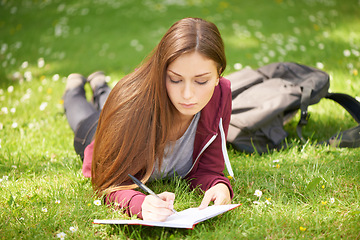 Image showing Woman, student and grass for writing, notebook and planning at university, campus and park for studying. Girl, book and pen for education, learning and brainstorming on lawn at college in sunshine