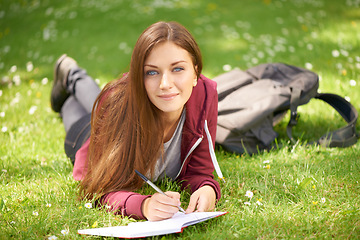 Image showing Woman, student and grass for writing, portrait or planning at university, campus or park for studying. Girl, book and pen for education, learning or brainstorming ideas on lawn at college in sunshine