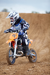 Image showing Motorcycle, sports and a child rider on a dirt track for racing, adventure or adrenaline outdoor during a hobby. Fitness, children and freedom with a boy kid on a bike for speed training or challenge