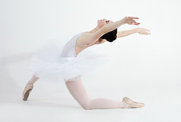 Image showing Creative, dance and ballet with a woman in studio on a white background for rehearsal or recital for theatre performance. Art, flexible and music with a young female ballerina or dancer in uniform