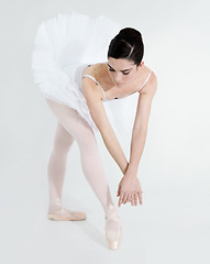 Image showing Art, dance and ballet with a woman in studio on a white background for rehearsal or recital for theatre performance. Training, creative and flexible with a young female ballerina or dancer in uniform