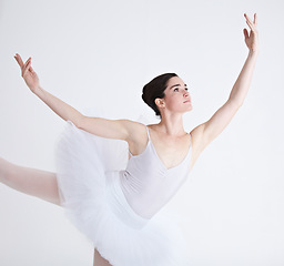 Image showing Music, dance and ballet with a woman in studio on a white background for rehearsal or recital for theatre performance. Art, creative and focus with a young female ballerina or dancer in uniform