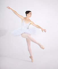 Image showing Elegance, dance and ballet with a woman in studio on a white background for rehearsal or recital for theatre performance. Art, creative and balance with a classy young ballerina or dancer in uniform