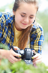 Image showing Woman, camera and photography in nature for plant, leaves and growth in garden, park and summer sunshine. Girl, photographer and travel in countryside with focus, memory and outdoor with plants