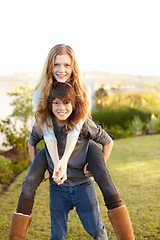 Image showing Boy, girl and portrait with piggy ride in the outdoor with happiness or playful summer. Happy, brother and embrace sister in garden with hug or back for bond or love with sunshine on weekend.