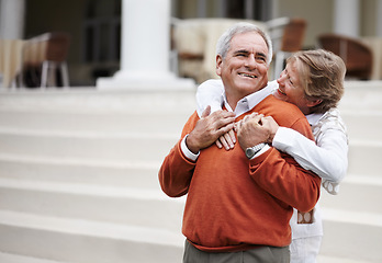 Image showing Hug, retirement and an old couple on hotel steps for travel, vacation or tourism in luxury accommodation. Love, relax or hospitality with a senior man and woman hugging on the staircase of a resort