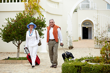 Image showing Hotel, vacation and elderly couple walking with suitcase in a holiday location happy in retirement and travel together. Bag, smile and senior people on a journey or man and woman walk in happiness