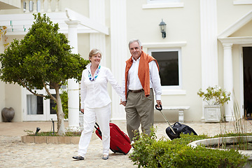 Image showing Hotel, vacation and senior walking people with suitcase in a holiday location happy in marriage and retirement together. Bag, smile and elderly couple on a journey or man and woman walk in happiness