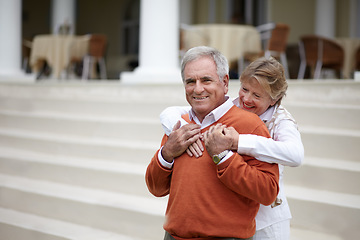 Image showing Hug, hospitality and an old couple on hotel steps for travel, vacation or tourism in luxury accommodation. Love, relax or retirement with a senior man and woman hugging on the staircase of a resort