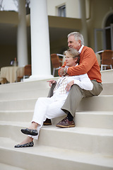 Image showing Hug, love and an old couple on hotel steps for travel, vacation or tourism in luxury accommodation. Retirement, relax or hospitality with a senior man and woman hugging on the staircase of a resort