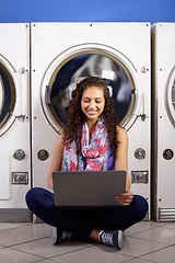 Image showing Happy, working and a woman with a laptop at a laundromat for college project, connection and multitask. Smile, education and a young female student reading on a computer while washing clothes