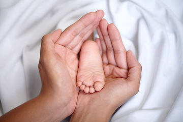 Image showing Hands, newborn and closeup of a baby foot with mother holding for care, love and nurture. Childcare, cute and zoom of a woman with her infant child feet in the crib of nursery at their family home.