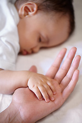 Image showing Closeup, hands and baby sleeping, care and nurture with love, support and relaxing with protection. Zoom, fingers and palms with infant, toddler or newborn with mother, asleep and family with comfort