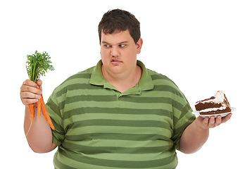 Image showing Plus size, diet decision and angry man with a carrot and cake choice thinking about balance. Upset male model, studio and white background with healthy and dessert feeling hungry and frustrated